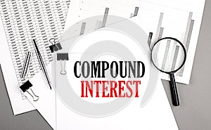 COMPOUND INTEREST text on paper on chart background