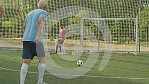 Compound training of soccer goalie on football pitch at daybreak