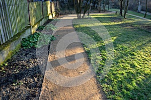 Compressing the gravel of the new park threshing path. lawn seed is repaired by rolling a metal hand roller, which is filled with