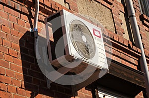 Compressor machine of the air conditioning system installed on a brick wall outside