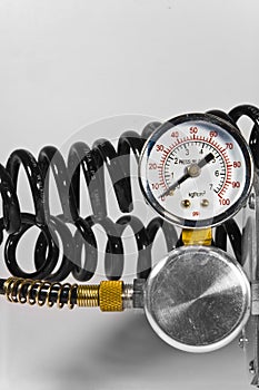 Compressor pressure gauge with black pipes.