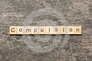 compulsion word written on wood block. compulsion text on table, concept photo