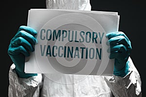 Compulsory vaccination note on poster, medical worker holding paper with text