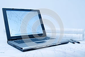 Computer and architectural plans in blue tint