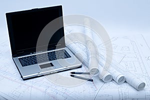 Computer and architectural plans in blue tint