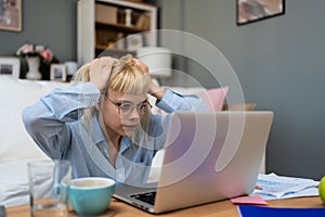 Computer bug. Young nervous frustrated freelance woman in home office having trouble with laptop or internet connection Anxious