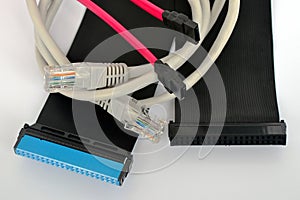 Computer cables of black, pink and gray colors picturesquely lie on a white background, concept connection photo