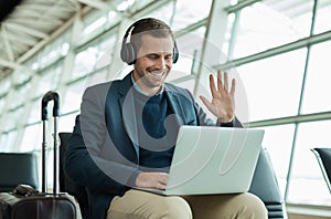 Computer call, wave and business man at an airport in a online meeting ready for work travel. Consulting, businessman