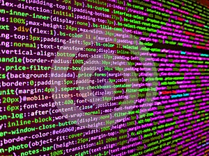 Computer code on laptop web developing. Big data storage and cloud computing representation. Binary computer code background,