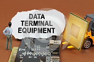 On the board with microcircuits lies a paper plate with the inscription - Data Terminal Equipment photo