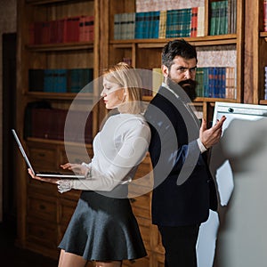 Computer concept. Woman and man develop new project using computer. University students surfing Internet in laptop