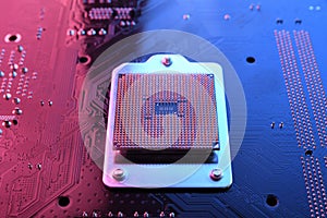 Computer cpu processor chip on circuit board ,motherboard background. Close-up. With red-blue lighting