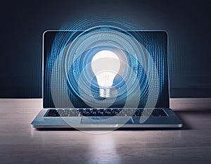 Computer on desktop with bulb icon hologram. Concept of idea.