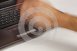 The computer does not want to work properly. A male hand violently striking a laptop touchpad