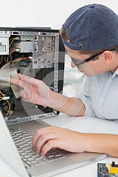 Computer engineer working on broken console with laptop