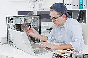 Computer engineer working on broken console with laptop