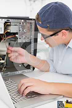 Computer engineer working on broken console with laptop