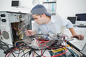 Computer engineer working on broken console with laptop