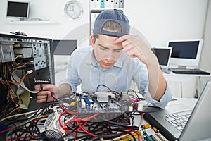 Computer engineer working on broken console with laptop