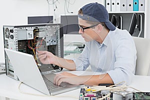 Computer engineer working on broken console with laptop