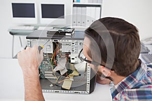 Computer engineer working on broken console with screwdriver