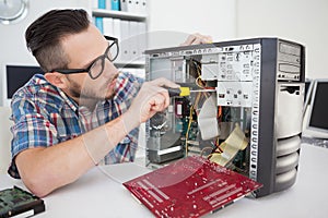 Computer engineer working on broken console with screwdriver