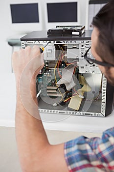 Computer engineer working on broken console with screwdriver