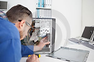 Computer engineer working on broken console with screwdriver