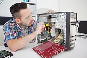 Computer engineer working on broken console with screwdriver
