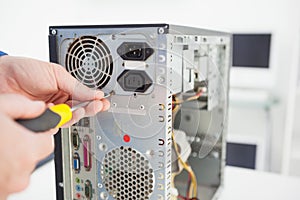 Computer engineer working on broken console with screwdriver