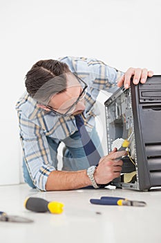 Computer engineer working on broken console with screwdriver