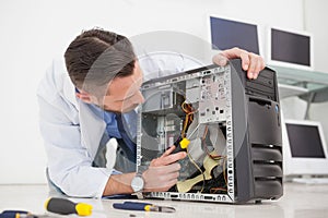 Computer engineer working on broken console with screwdriver