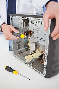 Computer engineer working on broken console with screwdriver