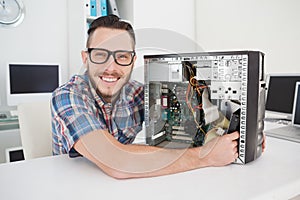 Computer engineer working on broken console smiling at camera