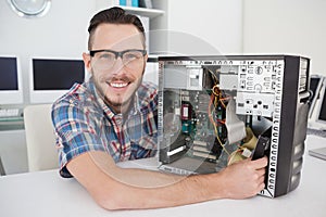 Computer engineer working on broken console smiling at camera