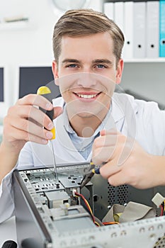 Computer engineer working on broken device with screwdriver