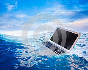 Computer failure concept with laptop on water