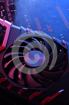 Computer game graphics card, videocard with two coolers on circuit board ,motherboard background. Close-up. With red-blue lighting