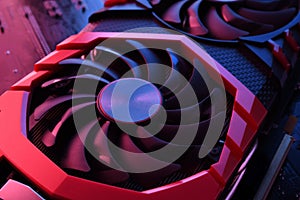 Computer game graphics card, videocard with two coolers on circuit board ,motherboard background. Close-up. With red-blue lighting