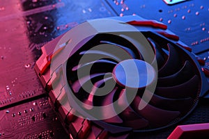 Computer game graphics card, videocard with two coolers on circuit board ,motherboard background. Close-up. With red-blue lighting