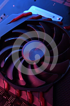 Computer game graphics card, videocard with two coolers on circuit board ,motherboard background. Close-up. With red-blue lighting