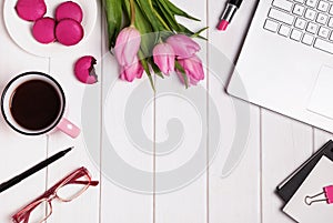 Computer, glasses, coffee and accessories in pink color on white