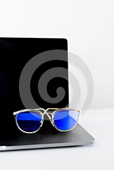 Computer glasses on laptop keyboard, blue light blockers