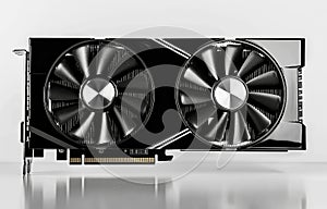 A computer graphics card with two fans on it is placed on a white surface