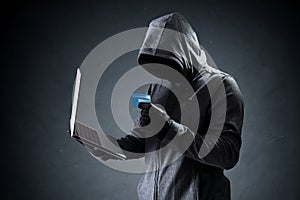 Computer hacker with credit card stealing data from a laptop