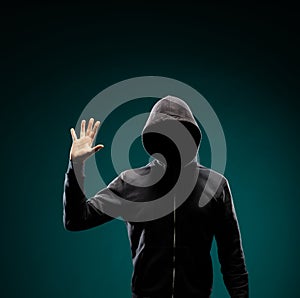 Computer hacker in hoodie. Obscured dark face. Data thief, internet fraud, darknet and cyber security concept.