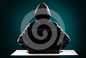 Computer hacker in hoodie. Obscured dark face. Data thief, internet fraud, darknet and cyber security concept.