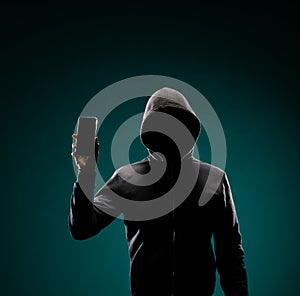 Computer hacker in hoodie. Obscured dark face. Data thief, internet fraud, darknet and cyber security concept. photo