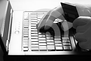 Computer hacker in white gloves stealing information on laptop