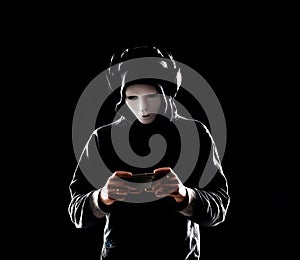 Computer hacker in white mask and hoodie. Obscured dark face. Data thief, internet fraud, darknet and cyber security